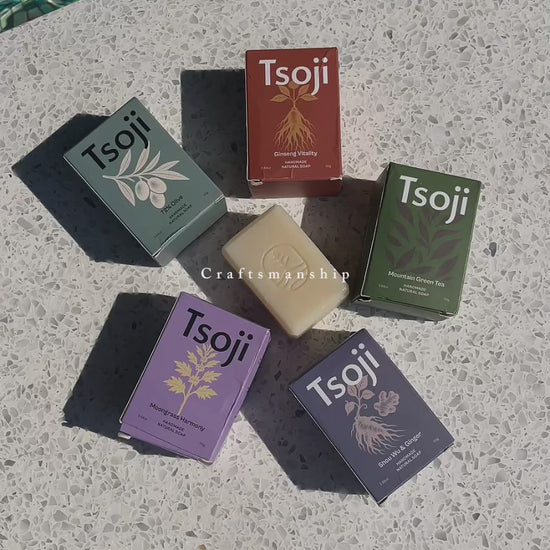 A video shot next to a pool in natural light showing Tsoji handmade all natural soaps Tsoji mountain green tea soap bar, Tsoji Ginseng Vitality soap bar, Tsoji Moongrass Harmony soap bar, Tsoji Shou Wu and Ginger soap bar, and Tsoji 72% Olive Soap bar one by one with the textured background matching the natural soap bars' texture