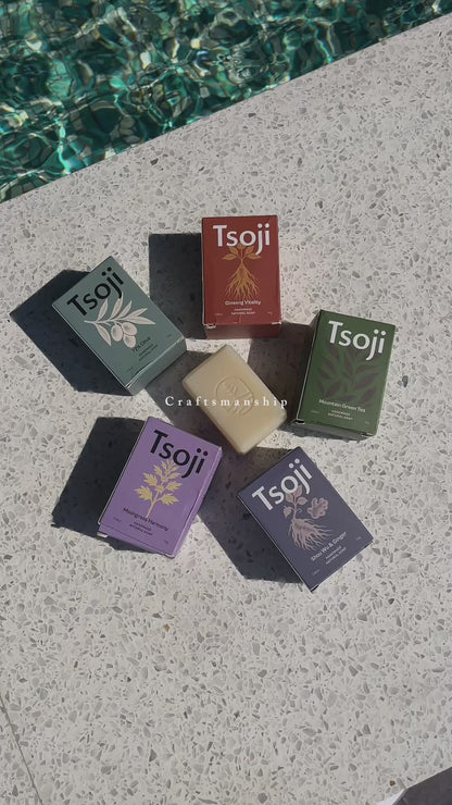 A video shot next to a pool in natural light showing Tsoji handmade all natural soaps Tsoji mountain green tea soap bar, Tsoji Ginseng Vitality soap bar, Tsoji Moongrass Harmony soap bar, Tsoji Shou Wu and Ginger soap bar, and Tsoji 72% Olive Soap bar one by one with the textured background matching the natural soap bars' texture