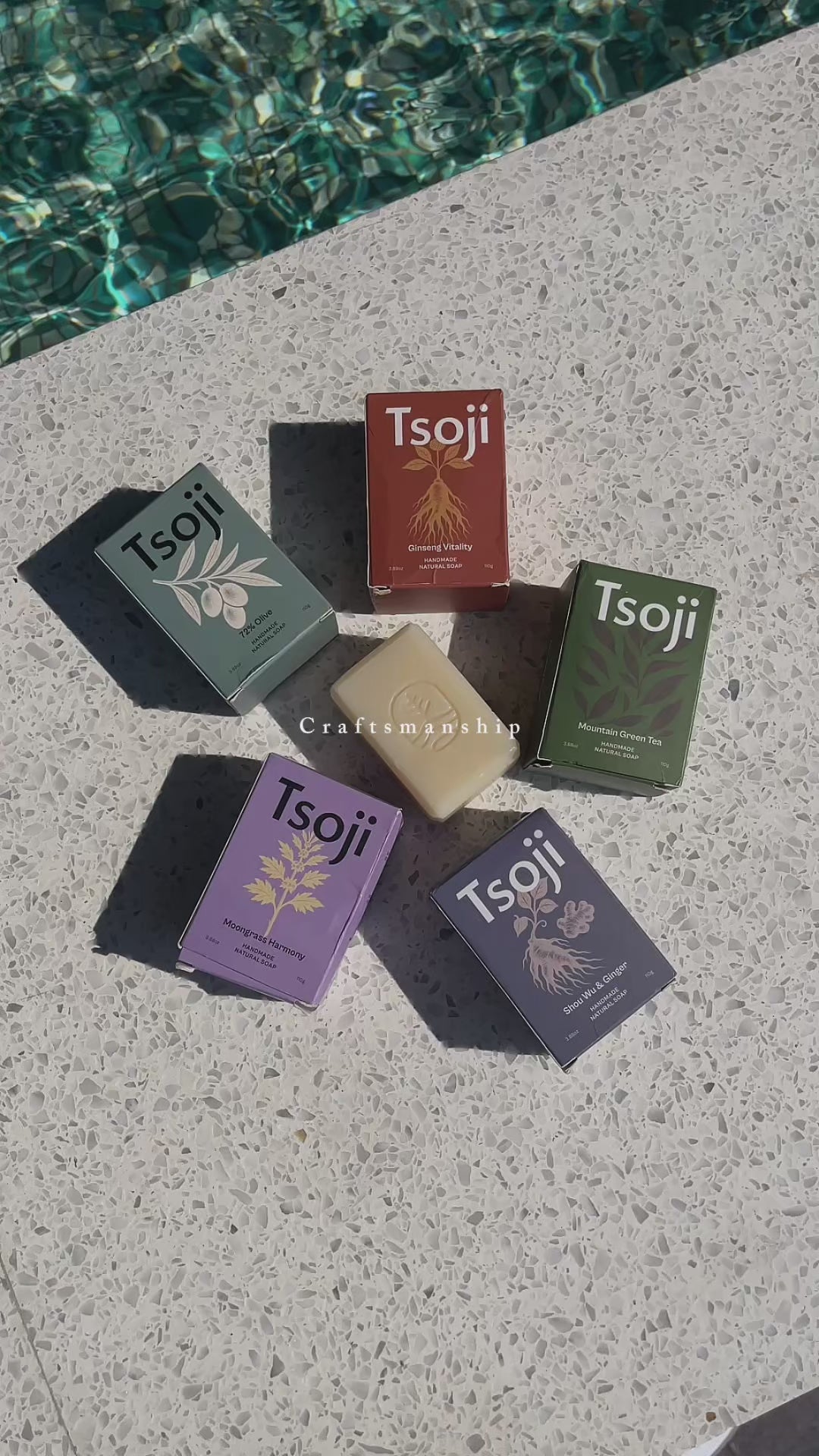 A video shot next to a pool in natural light showing Tsoji handmade all natural soaps Tsoji mountain green tea soap bar, Tsoji Ginseng Vitality soap bar, Tsoji Moongrass Harmony soap bar, Tsoji Shou Wu and Ginger soap bar, and Tsoji 72% Olive Soap bar one by one with the textured background matching the natural soap bars' texture